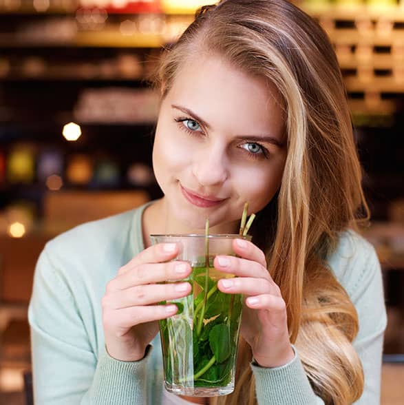 Mujer sonriendo bebiendo de un vaso