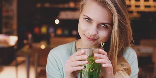 Mujer mirando a la camara bebibendo un refresco