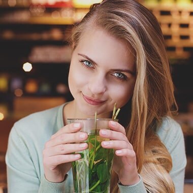 Mujer mirando a la camara bebibendo un refresco