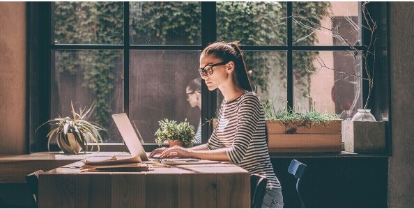Mujer con gafas revisando su computador