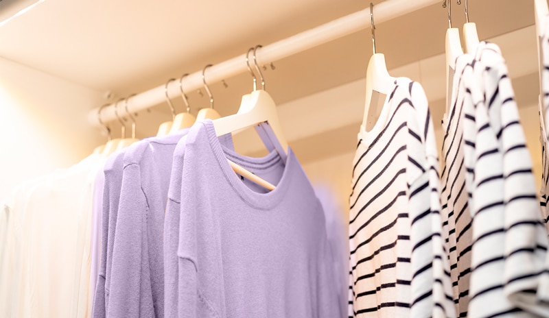 Ropa ajustada colgada en ganchos, mostrando una selección de prendas de estilo moderno.